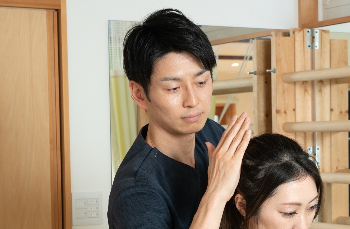 姿勢や痛みの原因を丁寧に説明している施術風景